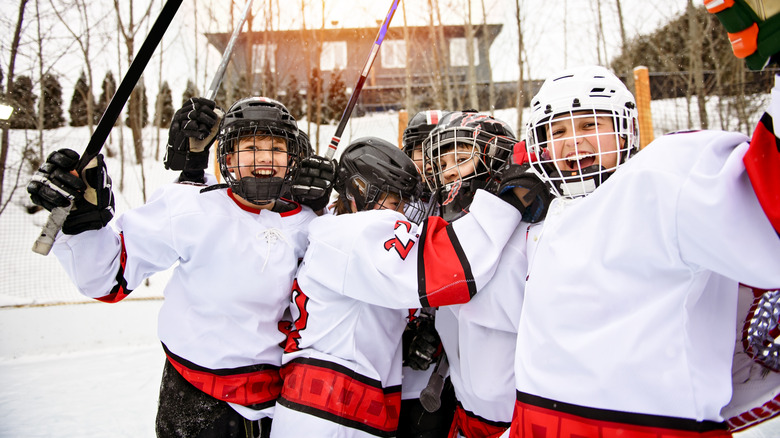 Kids playing ice hockey outside in winter