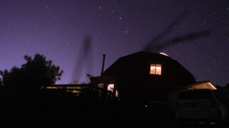 A geodome at The Domes Nature Retreat at night with a purple starry sky
