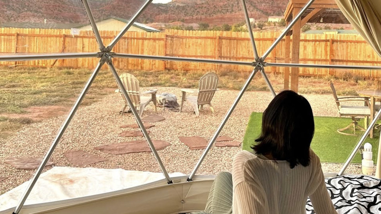 A woman laying on a bed in a geodome in White Camel