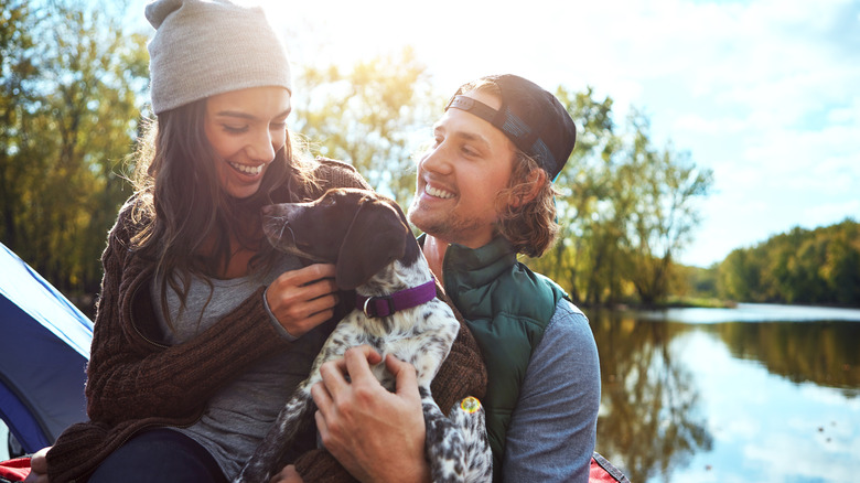 A couple holding a dog