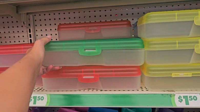 Hand reaching for pencil cases at Dollar Tree