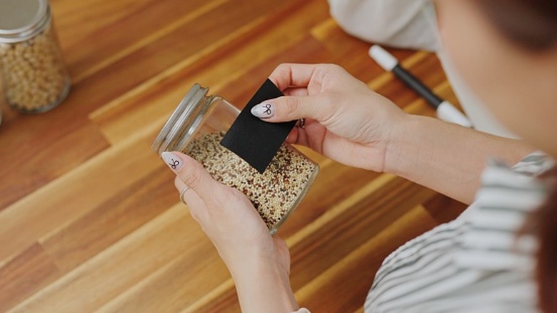 Hands putting a label on a jar
