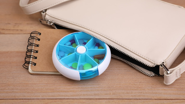 Pill organizers coming out of a purse