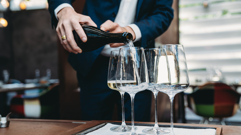 Man pouring prosecco into glasses