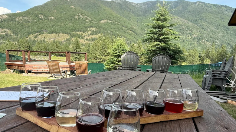A flight of wines at White Raven Winery in Columbia Falls, Montana, with mountains in the background