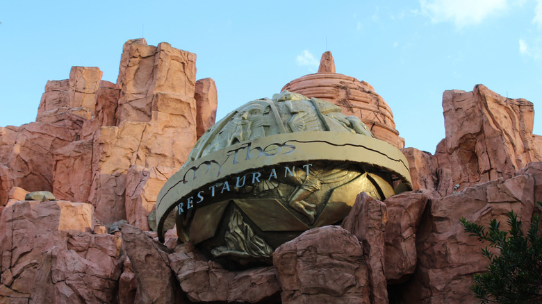 Facade of Mythos Restaurant at Universal's Islands of Adventure with carved rocks and gods-inspired gold signage.