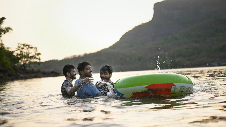 Three men on the water with a pool inflatable