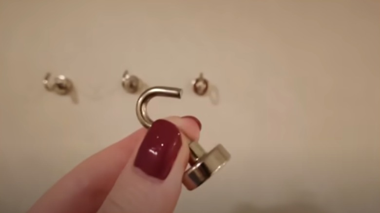 Hand placing magnet on wall