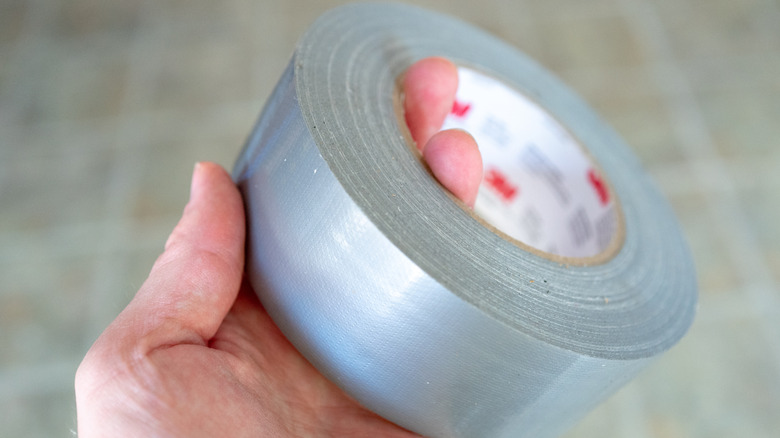 A hand holding duct tape
