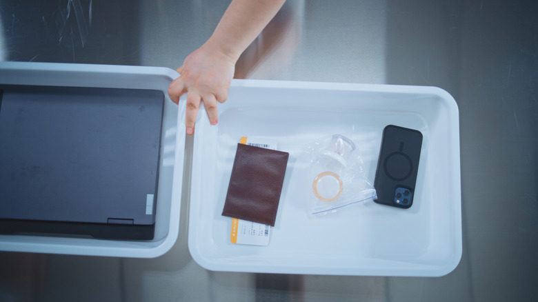 Passenger putting electronics in TSA bins