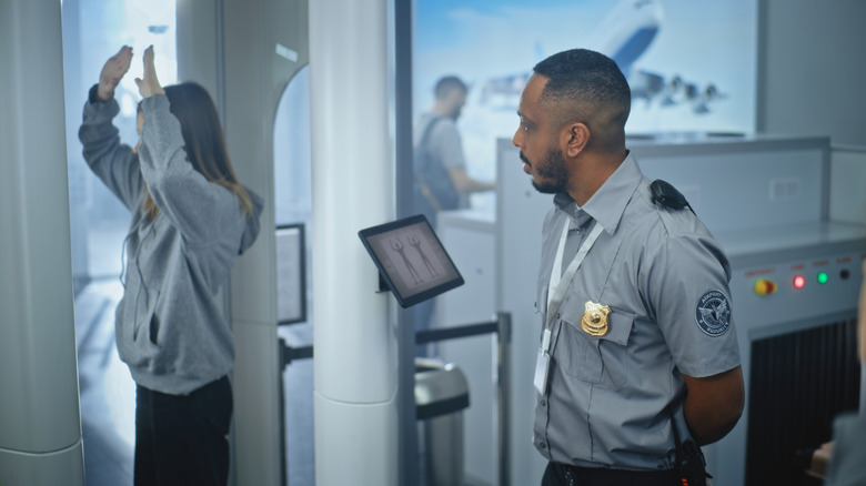TSA agent runs body scanner on female passenger