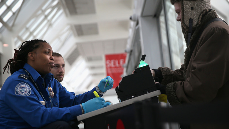 TSA agent checks passenger's documents, LaGuardia Airport, NYC