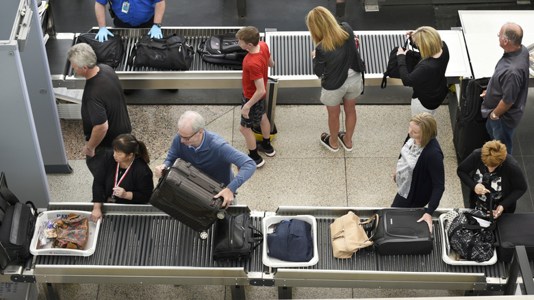 Bird's eye view of passengers at TSA conveyor belt