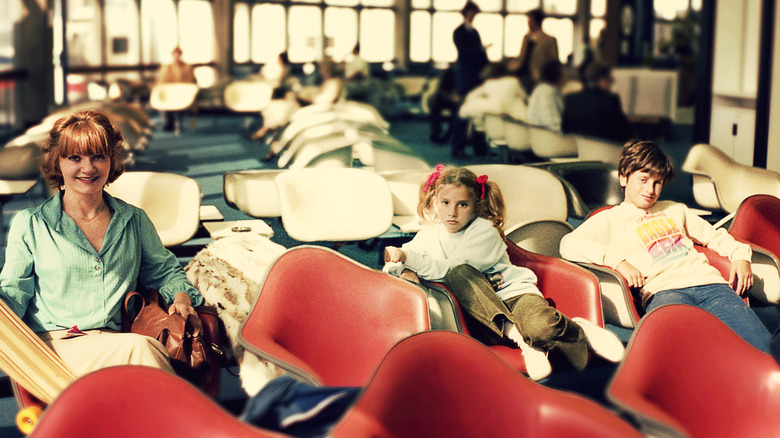 Family waiting in an airport lobby during the 1980s