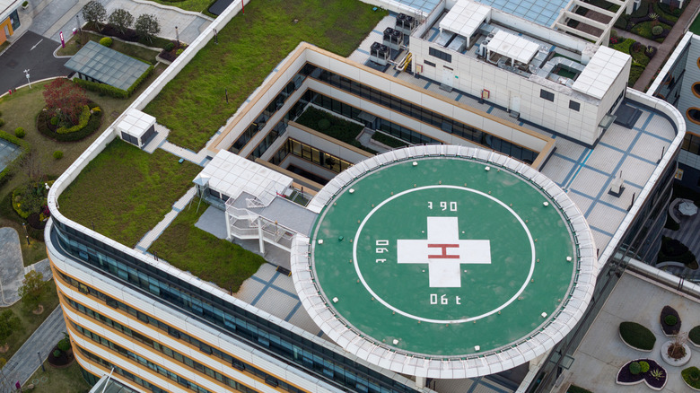 The roof of a hospital with a helipad and a white cross
