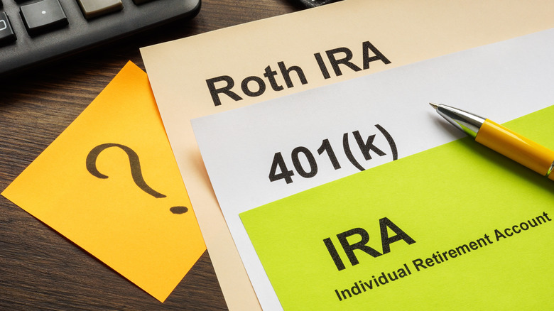 Printed notes about various retirement plans with a post-it note with a question mark underneath