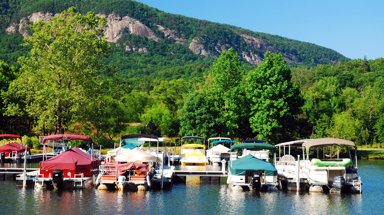 Pontoons and small boats are moored at a marina located in Lake Lure, North Carolina