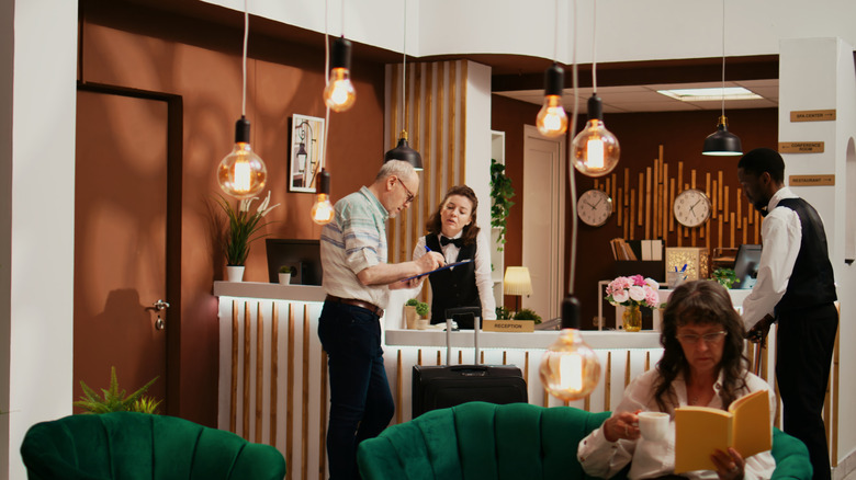 People at the check-in desk in a resort lobby