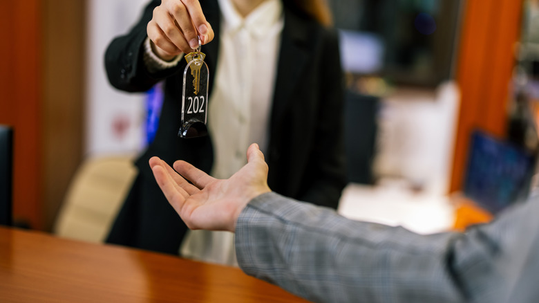 Hotel staff handing guest their room keys during check-in