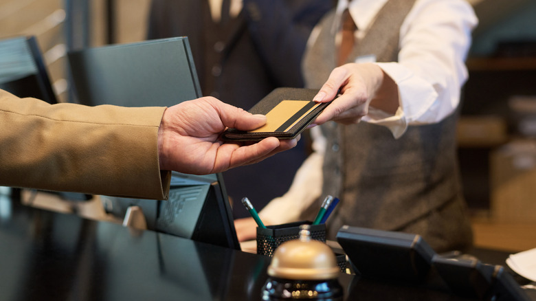 Closeup of hands exchanging documents during hotel check-in