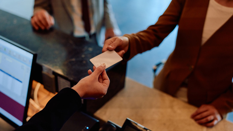 Hands exchanging a card during hotel check-in