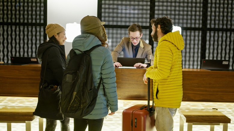 Group of travelers in puffer jackets at hotel check-in