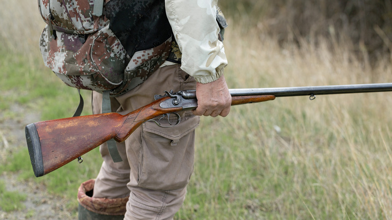 Close-up of a hunter's hand with a gun