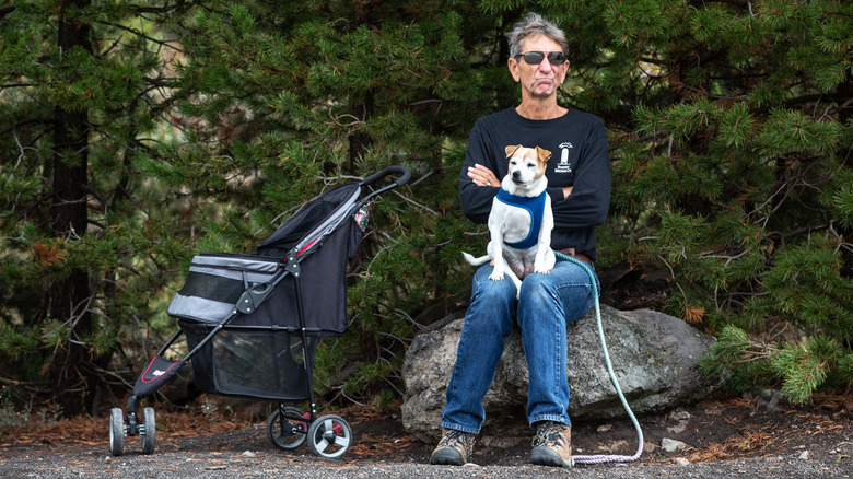 A man sits with his dog in Yellowstone National Park