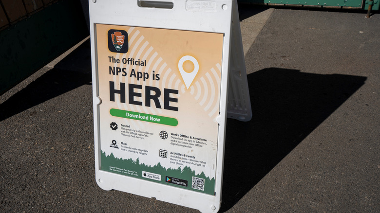 A sidewalk sign announcing the NPS App
