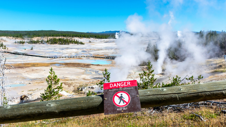 A danger sign on a walkway fence around hydrothermal features in Yellowstone National Park