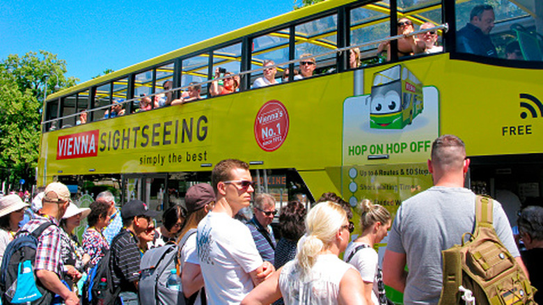 Large crowd of people waiting to board a sighseeing bus in Vienna