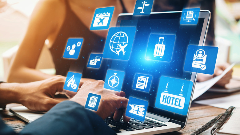 travel specific icons float over and around a laptop screen
