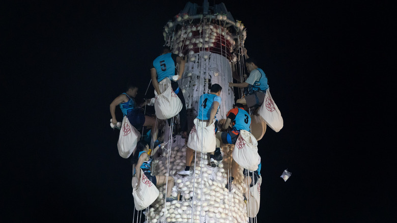 Men climb bun tower