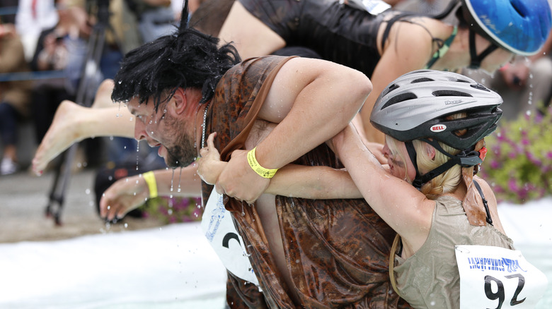 A man carrying a woman in water