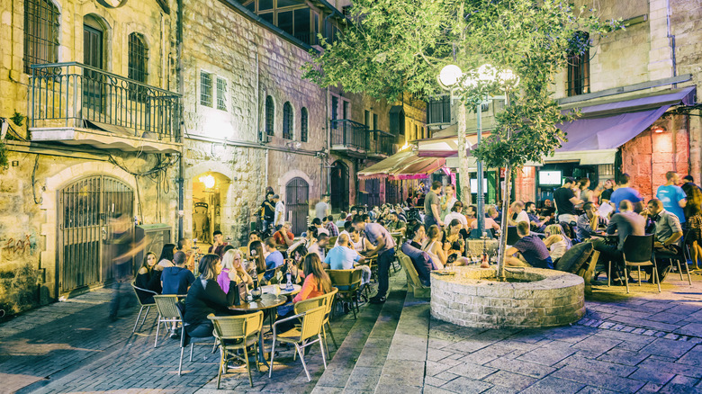 People sitting at tables at a sidewalk restaurant