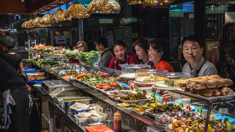 People eating at a market food stall in Barcelona