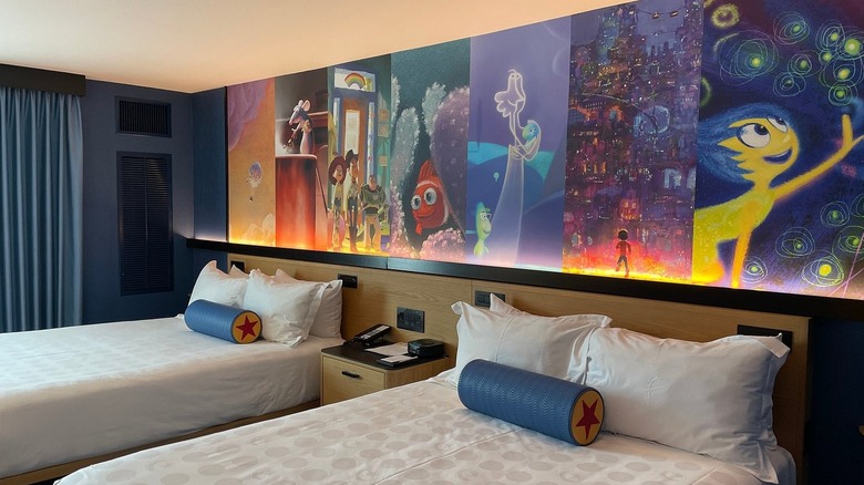 A bedroom in the Pixar Place Hotel in Anaheim, California, with a wall mural of animated Pixar characters