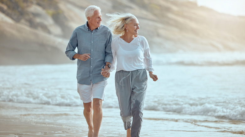 Retired couple walking on beach