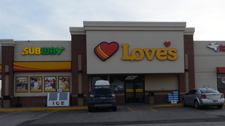 Parking lot with cars, store buildings.