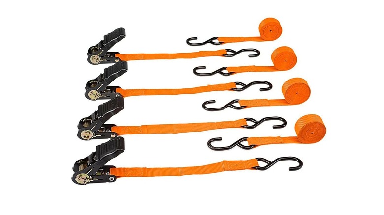 A set of four orange ratcheting tie-down straps on a white background
