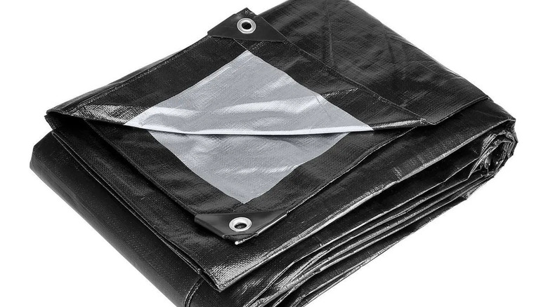 A folded black, heavy-duty, weather-resistant tarp on a white background