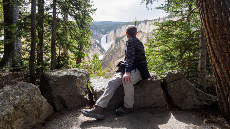 A tourist relaxes at Grand Canyon of the Yellowstone Overlook, Yellowstone National Park, Wyoming