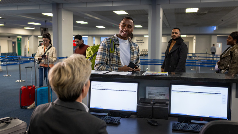 Airport passenger speaking with desk agent