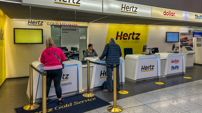 Airport travelers at rental car desk