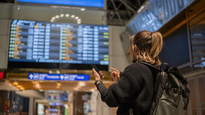 Traveler checking flight status at airport