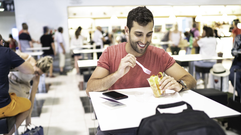 Traveler eating at airport food court