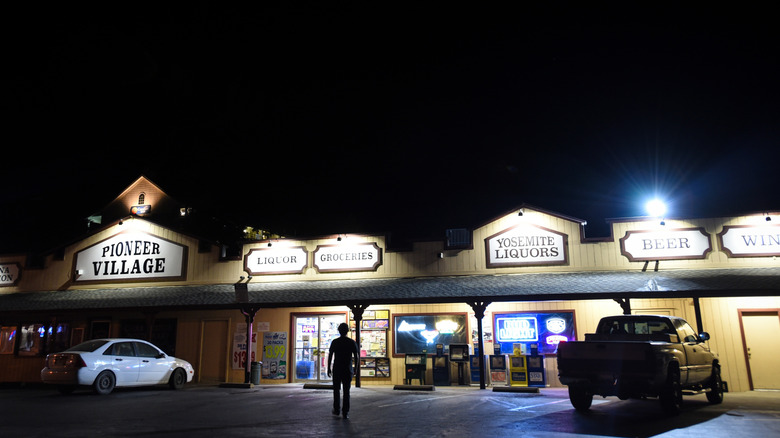 A young man walks into a grocery store in a business center in Mariposa, California