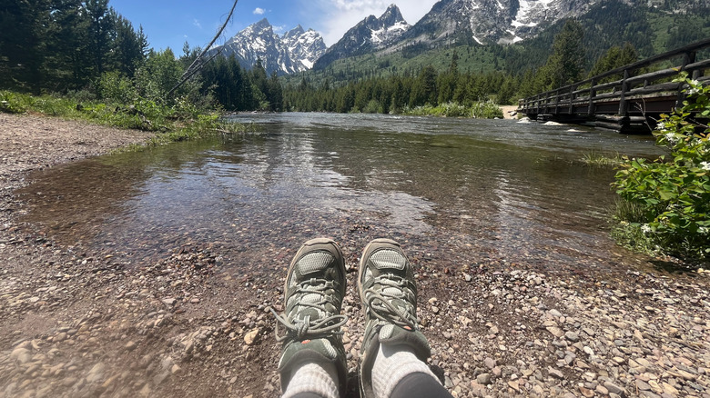 A photo of hiking boots next to a lake in Grand Teton National Park