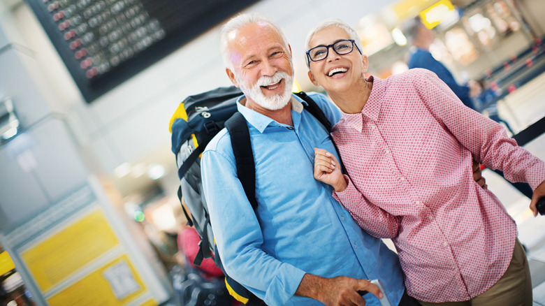 A smiling senior couple at the airport