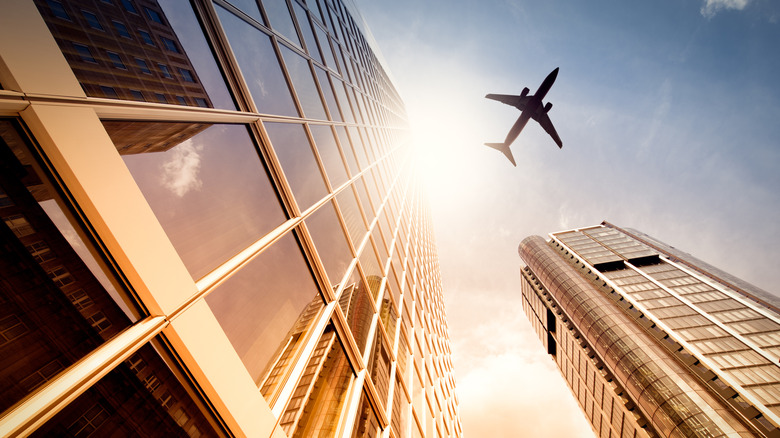 A skyscraper with an airplane silhouette in the sun